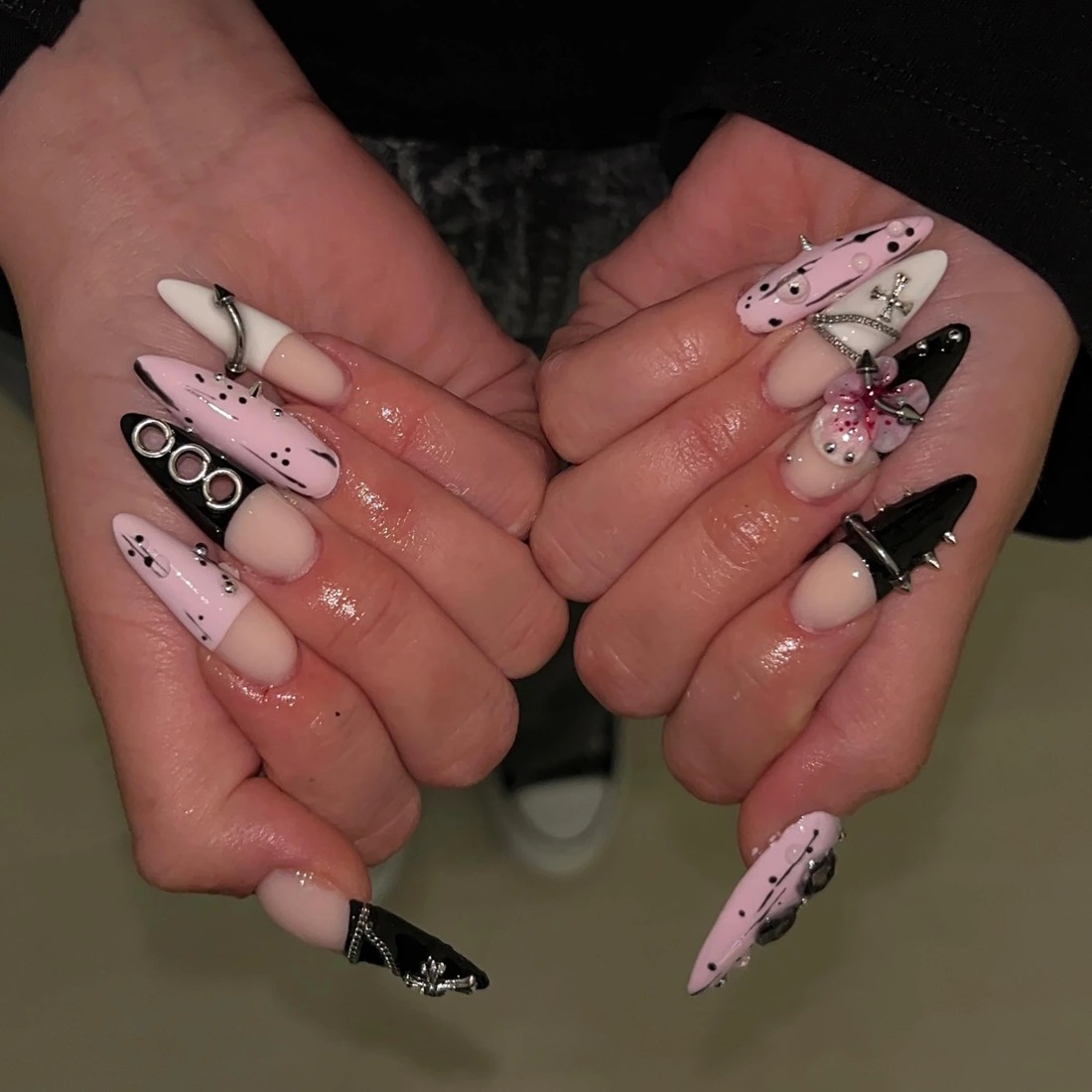 Lange Stiletto Nägel in Rosa und Schwarz mit Piercings, Ketten und Kreuzen